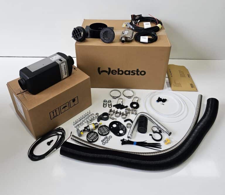 Webasto heater kit with boxed unit, wiring, hoses, clamps, vents and mounting hardware laid out on table